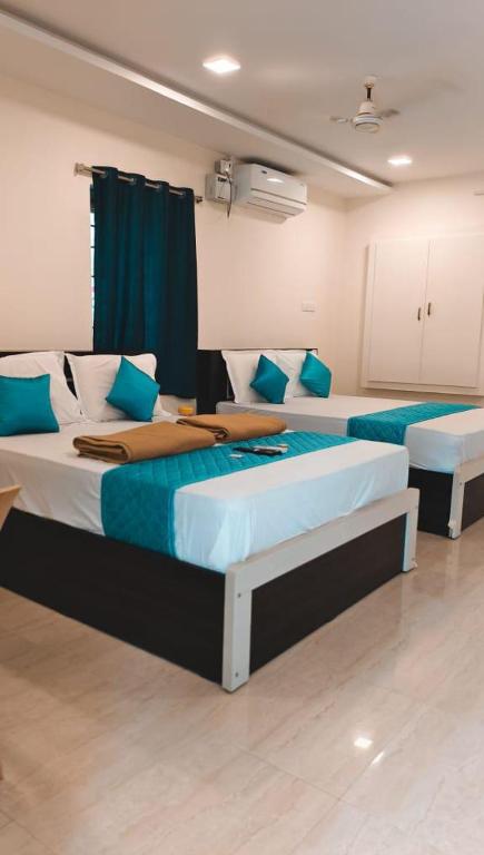 two beds in a room with blue and white at RCH Home Stay in Rāmeswaram