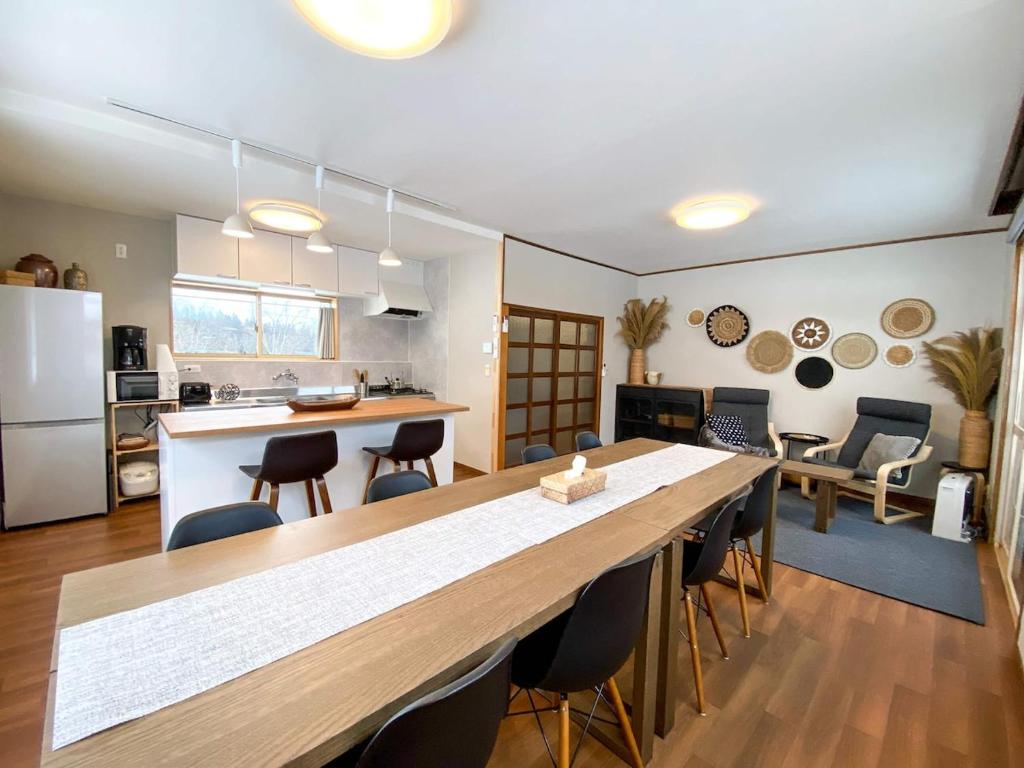 a kitchen and living room with a large table and chairs at KYŪKA Chalet in Myoko