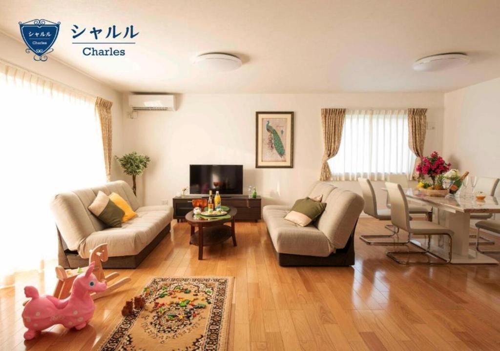 a living room with a couch and a table at Miyakojima Villa Charles in Miyako-jima
