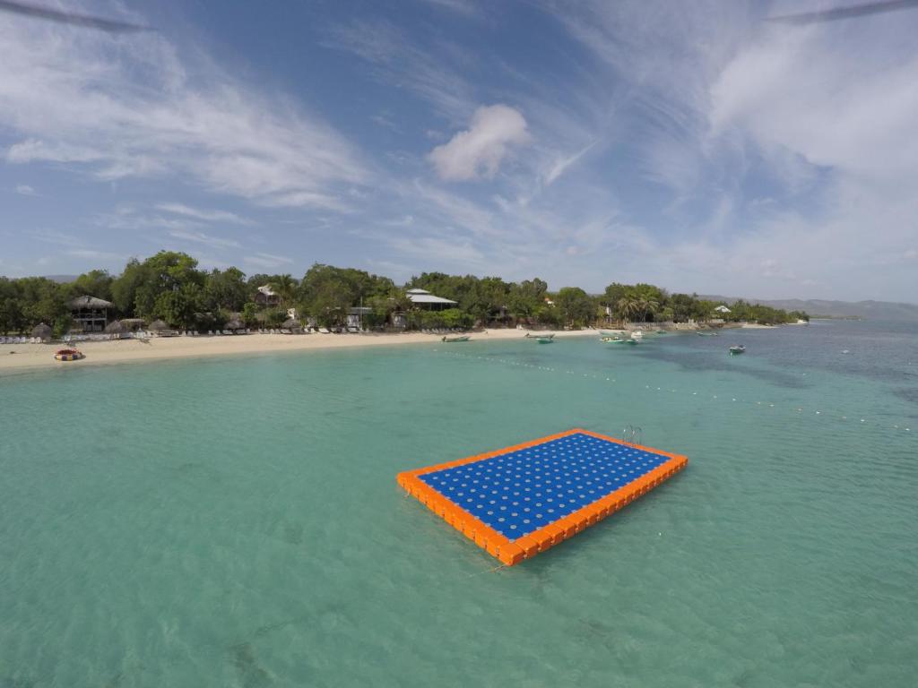 ein orangefarbenes und blaues Floß im Wasser am Strand in der Unterkunft Paradise Island Beach Resort in Punta Rucia