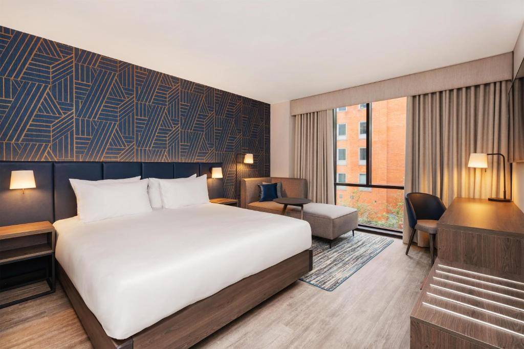 a hotel room with a bed and a desk at Hyatt Place Leeds in Leeds