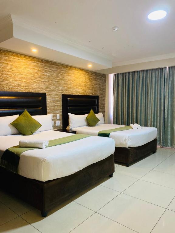 a hotel room with two beds in a room at Bayside Hotel 97 Russell Street in Durban