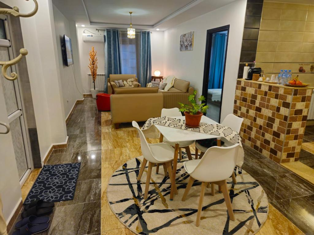 a living room with a table and chairs at Beau F3 in Dar el Beïda