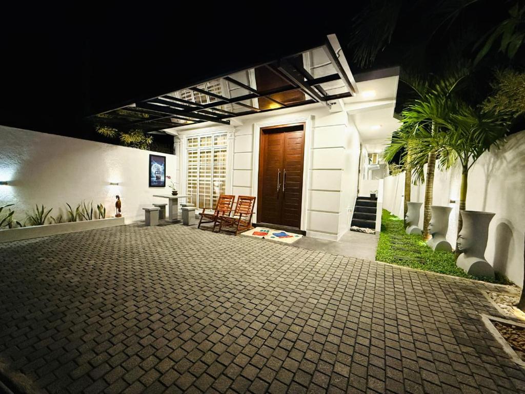 a porch of a house with a wooden door at Roo Ceylon Beach Villa in Matara