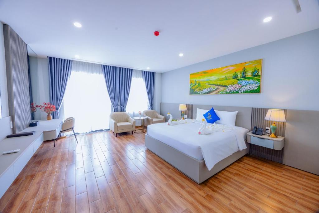 a hotel room with a bed and a table and chairs at Cannes Ben Tre Hotel in Ben Tre
