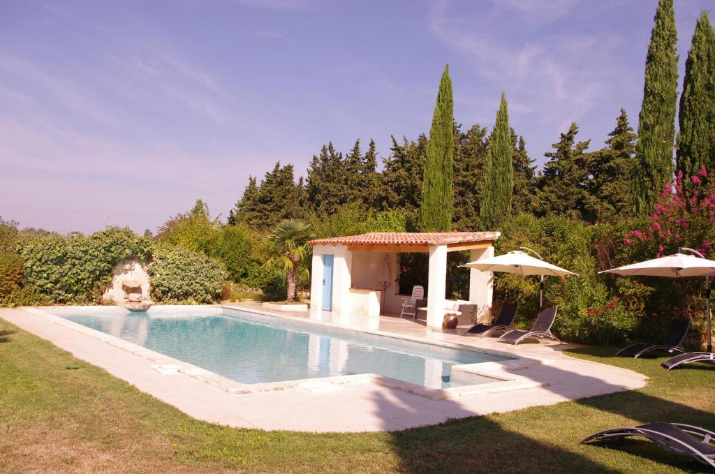 a swimming pool in a yard with umbrellas at Lei Meissoun in Mallemort