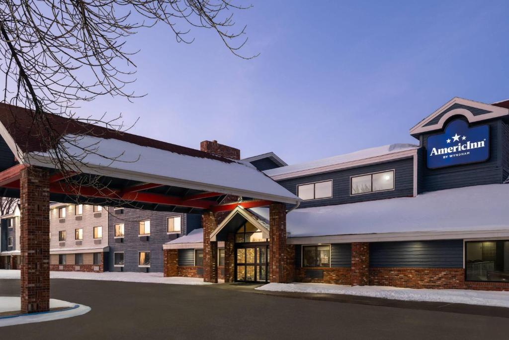 a hotel building with a sign that reads american inn at AmericInn by Wyndham Grand Forks in Grand Forks