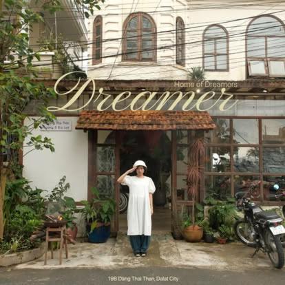 a woman standing in the doorway of a restaurant at Dreamershomecoffee in Xuan An