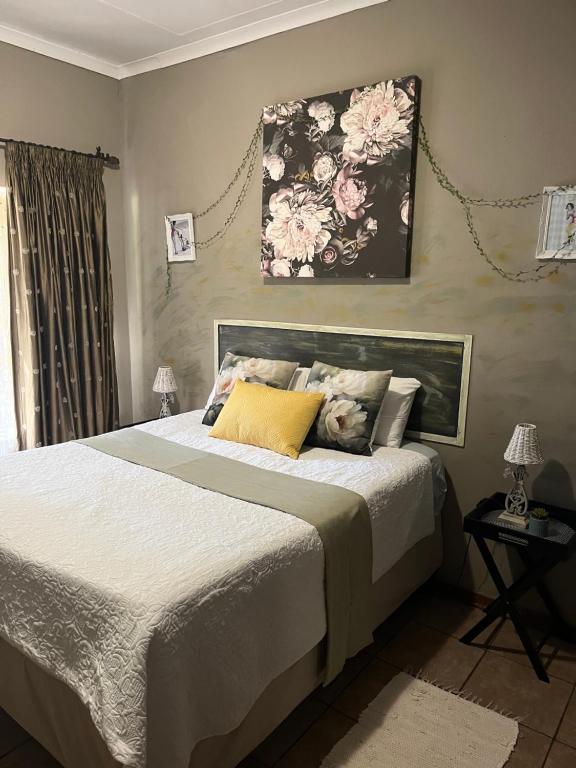 a bedroom with a bed and a painting on the wall at Cottage on Kort Deluxe in Parys