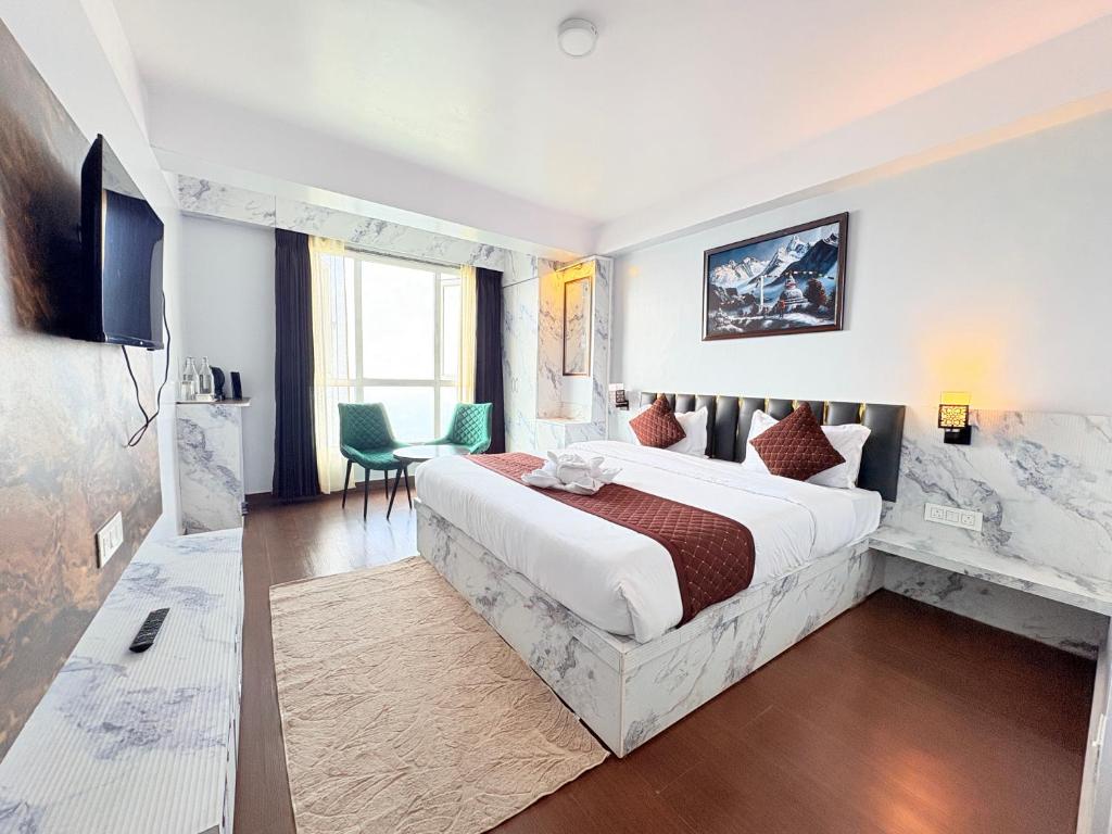 a hotel room with a large bed and a television at Singalila Retreat by Barsana Group Darjeeling in Darjeeling