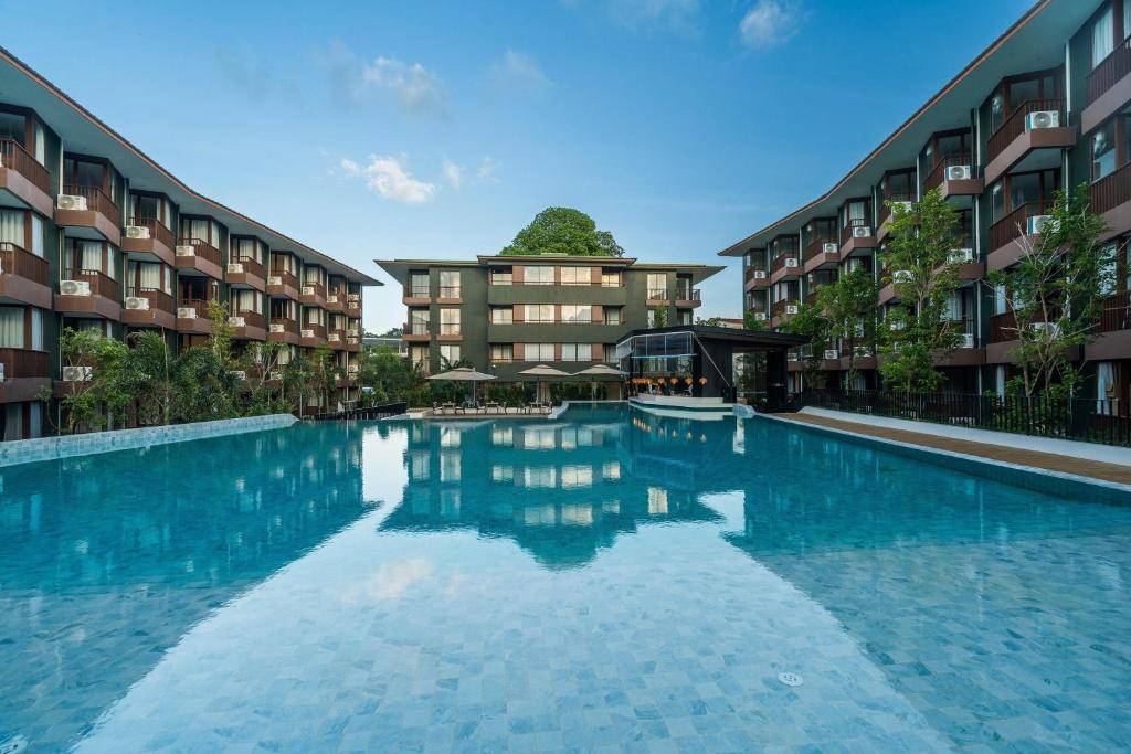 a large swimming pool in front of some apartment buildings at Wyndham Garden Samui Wing in Chaweng