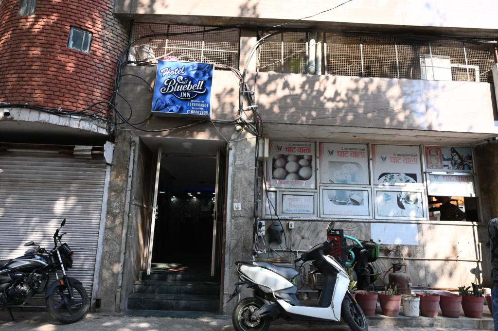 a scooter parked in front of a building with a sign at Hotel Bluebell Inn in Lucknow