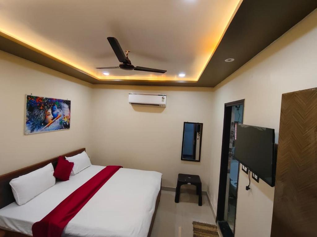 a bedroom with a bed and a flat screen tv at Royal Paradise Guest House in Varanasi