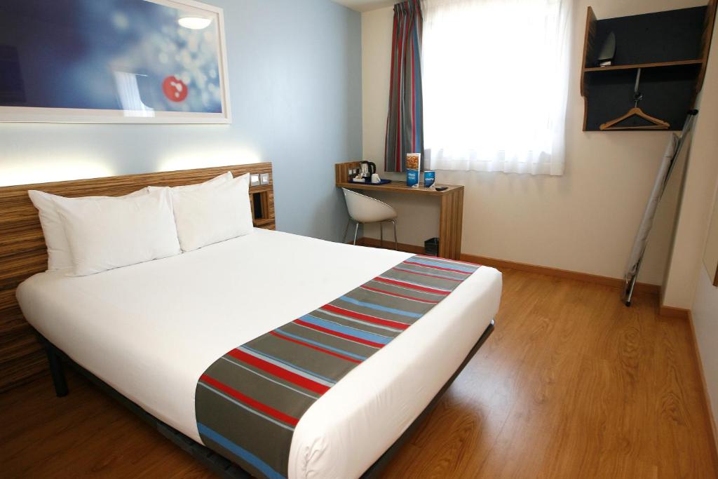 - une chambre avec un grand lit blanc et une fenêtre dans l'établissement Travelodge Barcelona Poblenou, à Barcelone