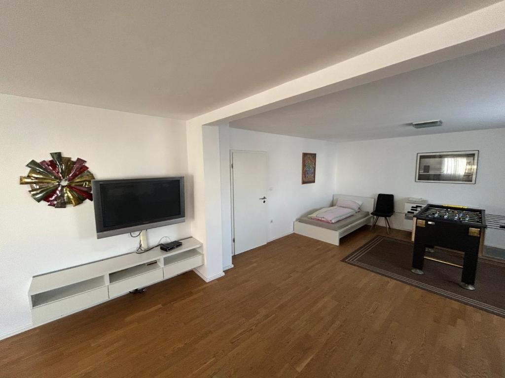 a living room with a flat screen tv and a couch at XL Apartment Rödermark 4SZ in Rödermark
