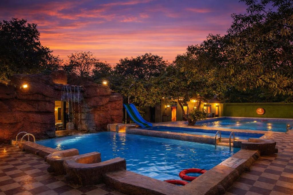 a swimming pool with a slide and a playground at Daksh Resort And Amusement Park in Sasan Gir
