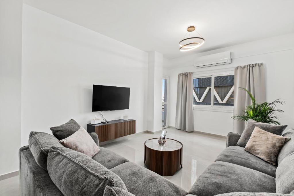 a living room with two couches and a tv at Mnasiadou Suite 16 in Nicosia