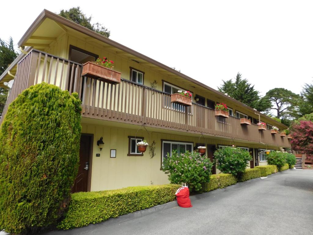 a yellow building with a red fire hydrant in front of it at Deer Haven Inn in Pacific Grove