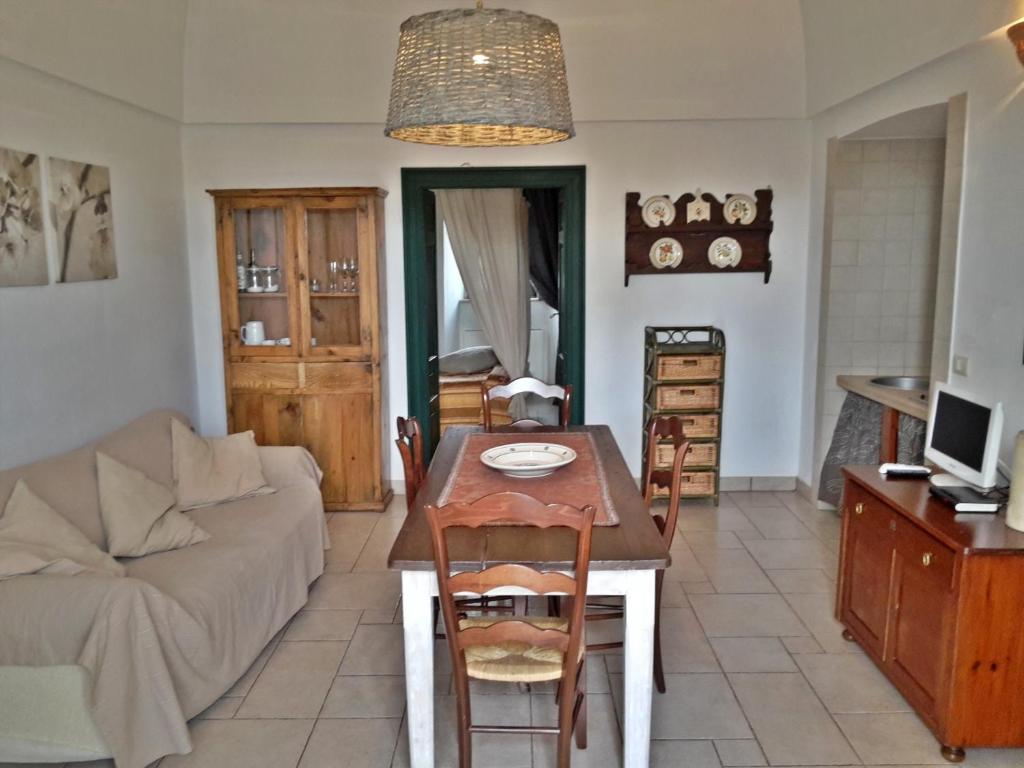 un salon avec une table et un canapé dans l'établissement Masseria Rosa Trulli Relais, à Alberobello