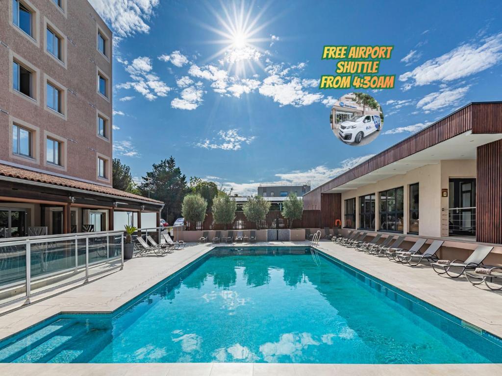 a pool at a hotel with chairs and a building at Best Western Marseille Aeroport in Vitrolles