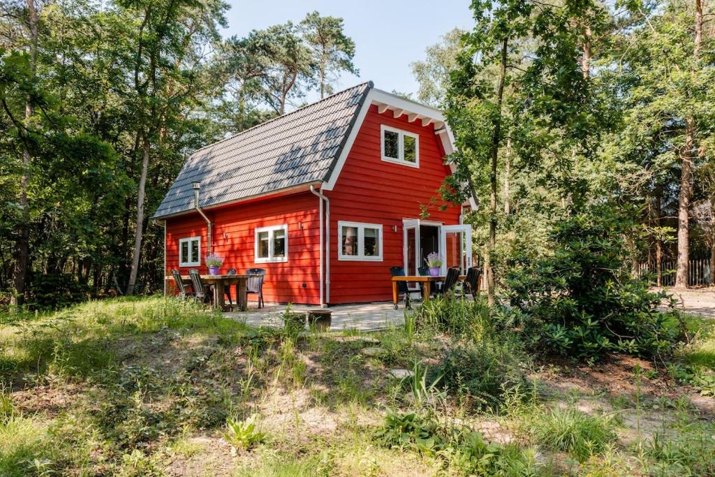 a red tiny house in the woods at Chalet Citola in Nuenen