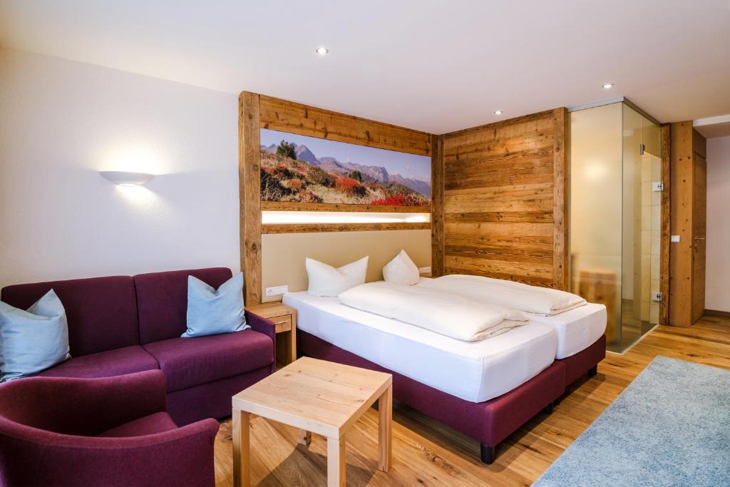 a hotel room with a bed and a couch at Hotel Central in Gerlos