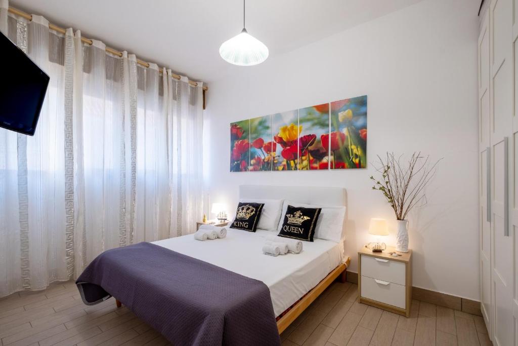 a bedroom with a bed and a painting on the wall at Areon - Central Coastal Residence in Porto Cesareo