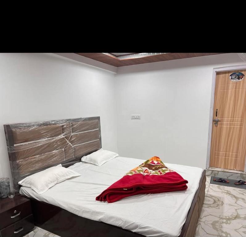 a bedroom with a bed with a red blanket on it at Paradise Banihal Hotel in Banihāl
