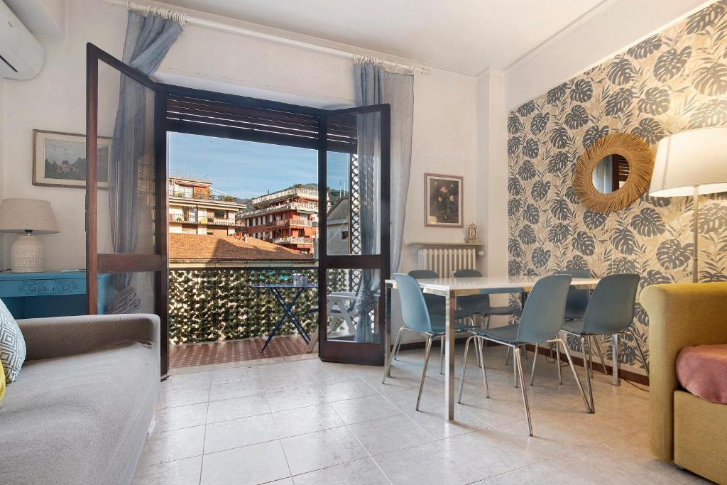 ein Wohnzimmer mit Tisch und Stühlen und einem Balkon in der Unterkunft Sweet 16 in Rapallo