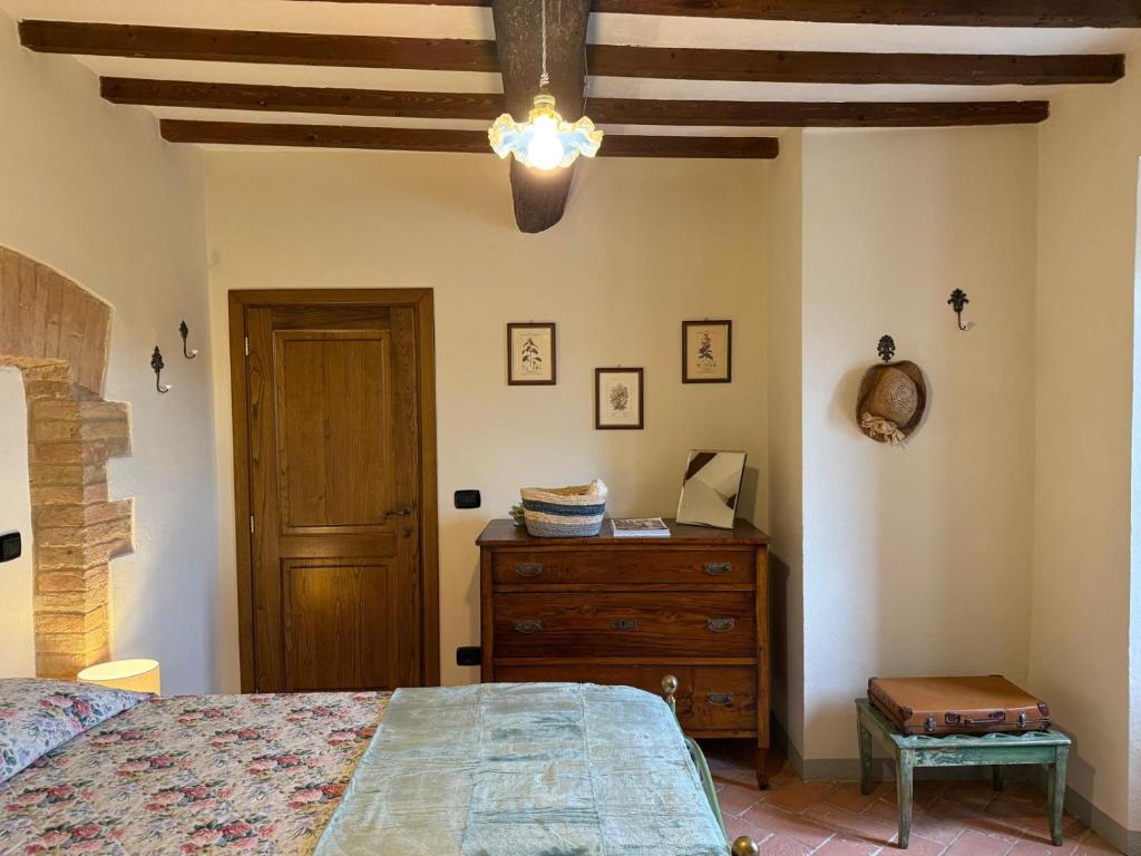 a bedroom with a bed and a dresser and a ceiling at Casina Gattoli - Casa Vacanze in Montalcino