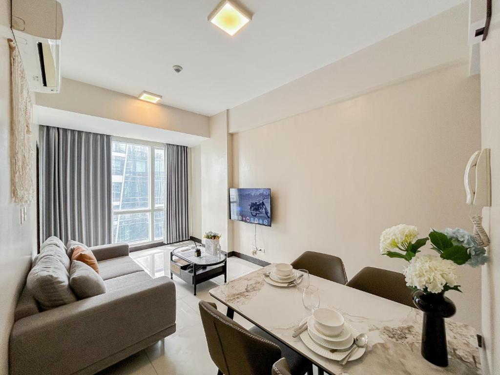 a living room with a couch and a dining room table at Modern 1BR w Exclusive Pool Access in Lapu Lapu City