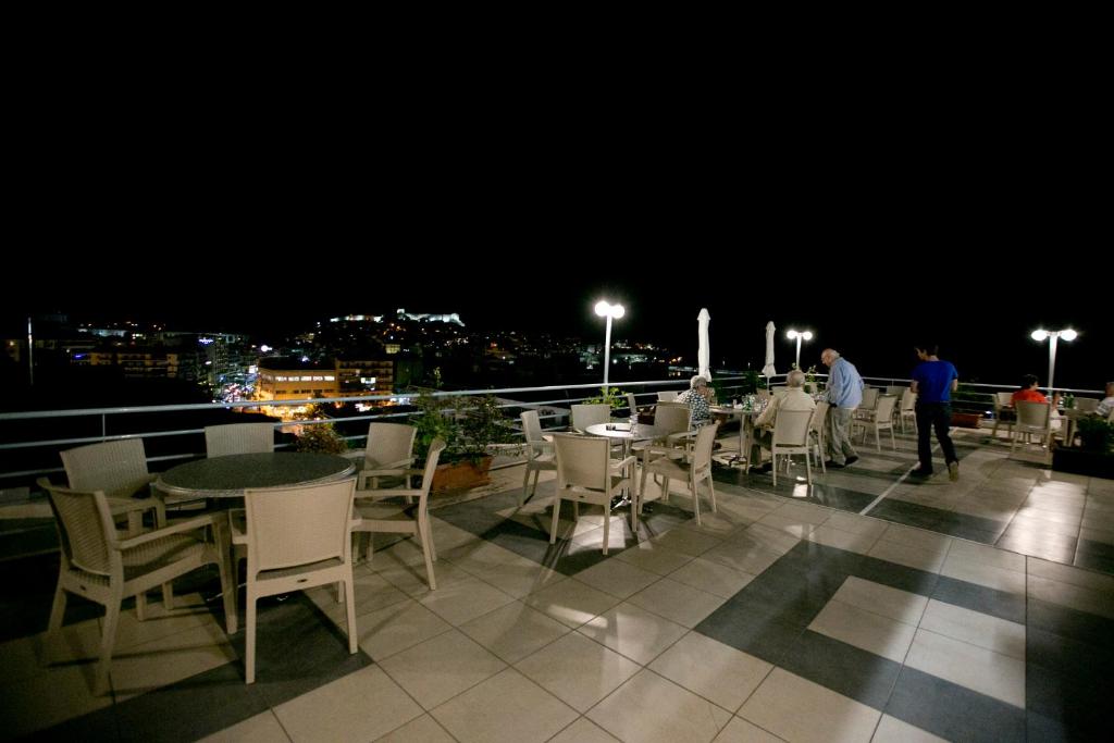 a table and chairs on a balcony at night at Oceanis Hotel in Kavála