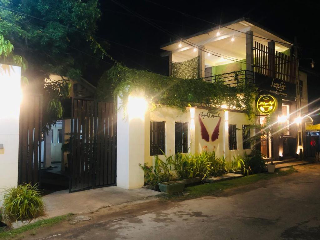 a white building with a gate at night at Angels Negombo in Negombo
