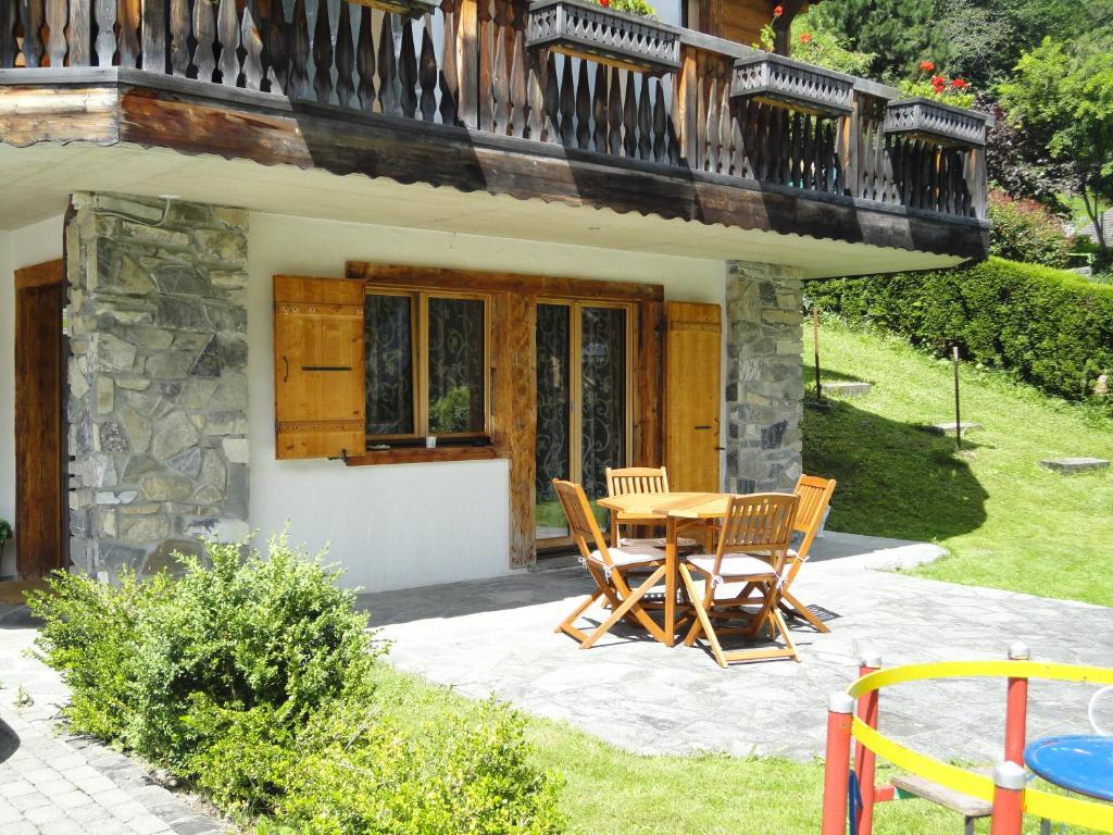 a patio with a table and chairs in front of a house at Chalet Hestia in Champéry
