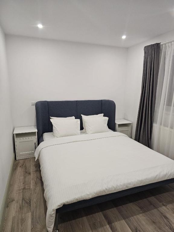 a bedroom with a large bed with white sheets at Trusted Home in Târgovişte