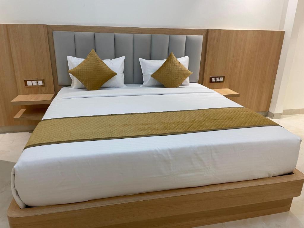 a bedroom with a large white bed with yellow pillows at Hotel Immense Plaza in Jāmb