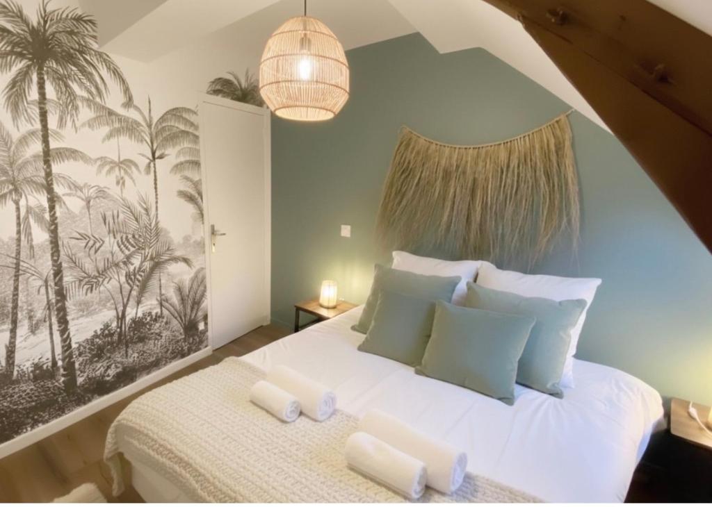 a bedroom with a white bed with a palm tree mural at La casa Terracotta - centre ville , spacieux & confortable in Béthune