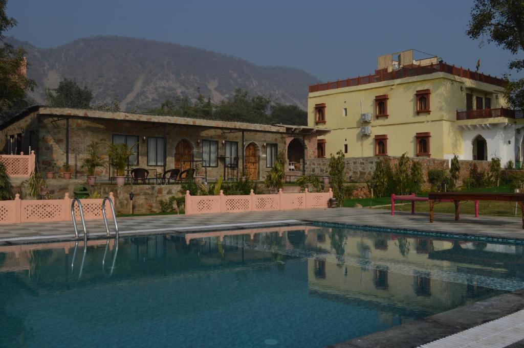 a house and a swimming pool in front of a building at Bagh Ajabgarh in Ajabgarh