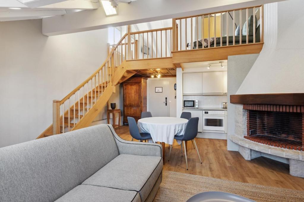 a living room with a couch and a table at Stylish Duplex Apartment in Morges