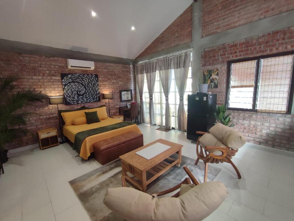 a bedroom with a bed and a brick wall at Forest Pool Villa in Ulu Melaka