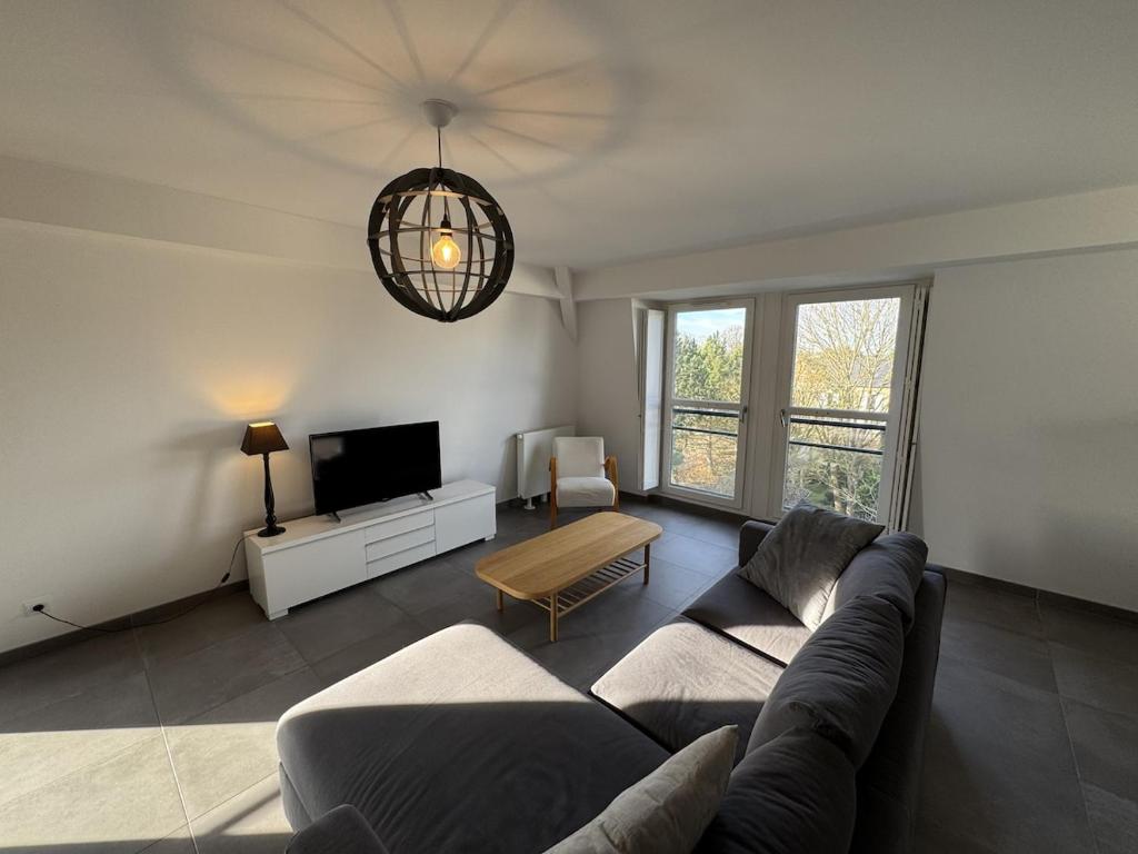 a living room with a couch and a tv at Appartement moderne Senlis in Senlis