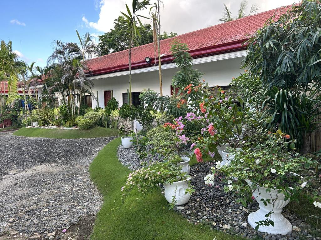 a garden with flowers in white pots in front of a house at Seaside Villa in Dauis