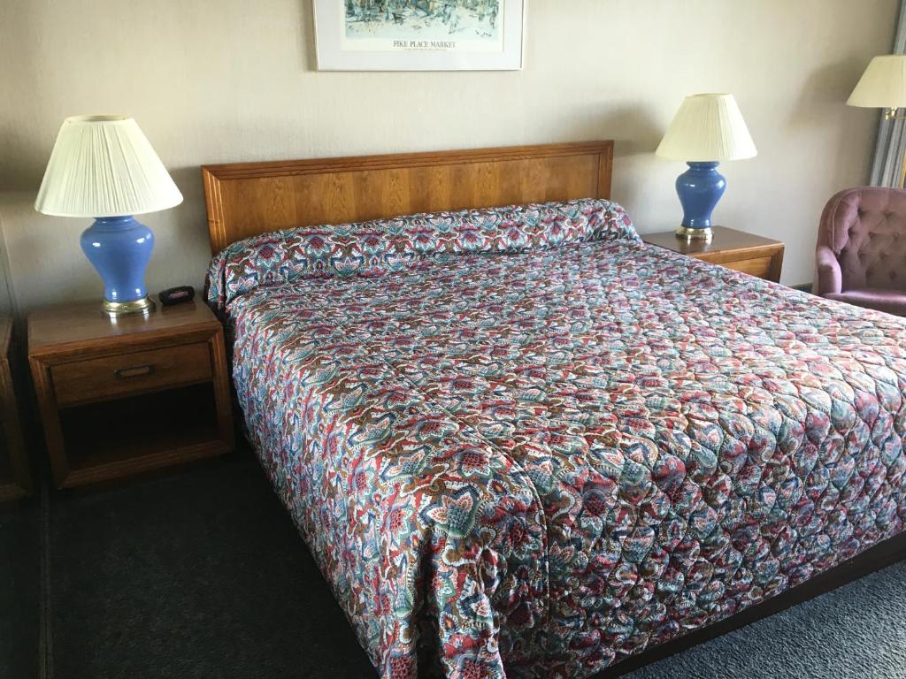 Cama en habitación con 2 lámparas y colcha en Flagship Inn en Bremerton