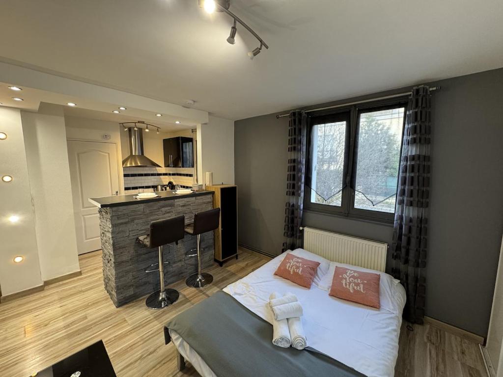 a bedroom with a bed and a bar in it at Studio fonctionnel Beauvais in Beauvais