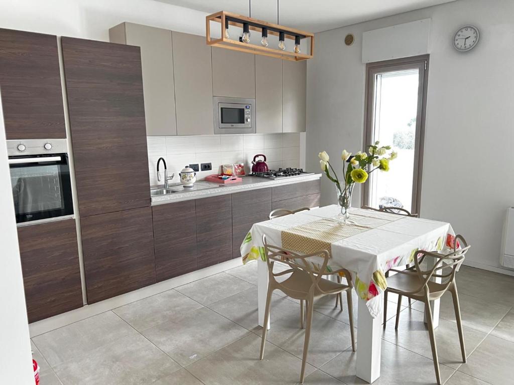 a kitchen with a white table and chairs and a kitchen with a counter at Brezza di Bari, Terrace & Free Parking, family and group apartment by Leviora Collection in Bari