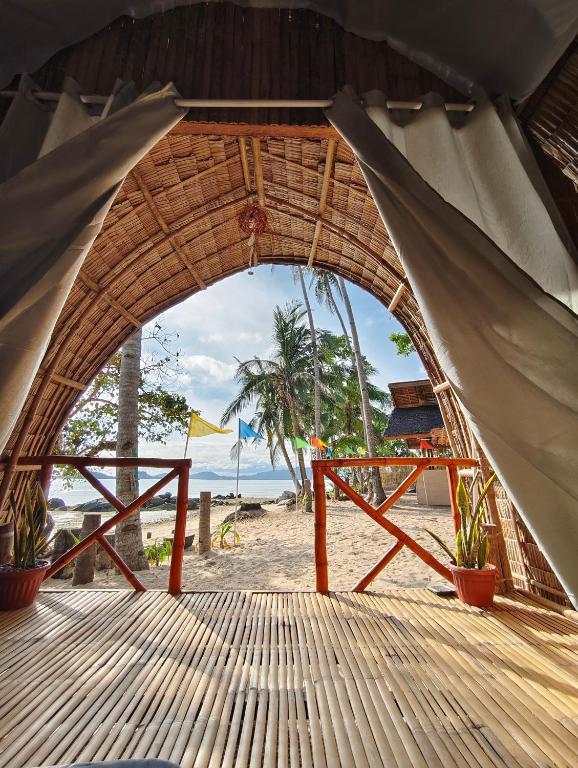 a view of the beach through an archway at EL-NARA SEASIDE Beach Resort in El Nido