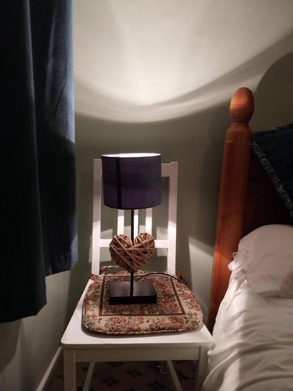 a lamp on a table next to a bed at 40 Hirst Grove in Hebden Bridge