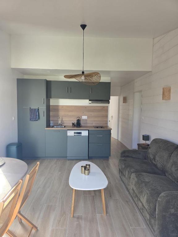 a living room with a couch and a table at Maisonnette près de la plage in Aytré