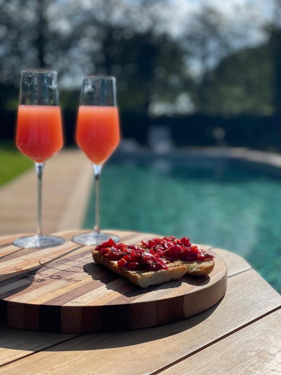 two wine glasses and a piece of bread on a cutting board at Veï Lou Quéri in Moutier-Malcard