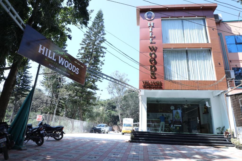 a sign in front of a building with motorcycles parked outside at Hill Woods Yelagiri in Yelagiri